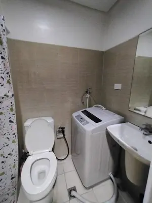 a bathroom with a white toilet and a sink at Shore 1 Residences - 1 Bedroom with Balcony in Manila