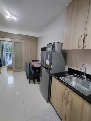 a kitchen with a stainless steel refrigerator and a table at Shore Residences - 1 Bedroom with Balcony in Manila