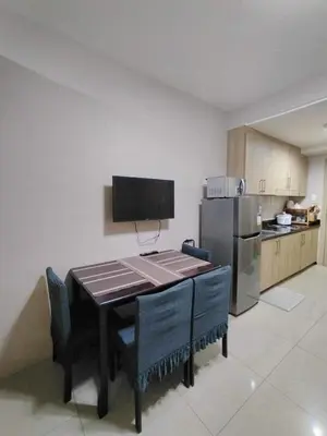 a kitchen with a table with chairs and a refrigerator at Shore Residences - 1 Bedroom with Balcony in Manila
