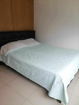 a bedroom with a bed with a white blanket on it at spacious 1 br fully furnished condo in Manila