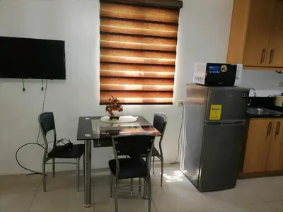 a kitchen with a table with chairs and a refrigerator at spacious 1 br fully furnished condo in Manila