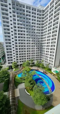 a large building with a large pool in front of it at VM Staycation Grace Residence Taguig in Manila