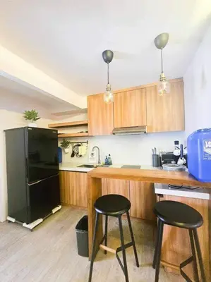 a kitchen with a black refrigerator and two bar stools at Instragamable2BR near Bridgetown in Manila