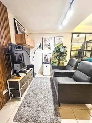 a living room with a couch and a tv at Instragamable2BR near Bridgetown in Manila