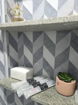 a shelf with a remote control and a plant on it at Spacious Apartment near Evia Daang Hari in Manila