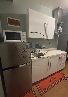 a kitchen with a refrigerator and a microwave at MetroNest Dettifoss in Manila