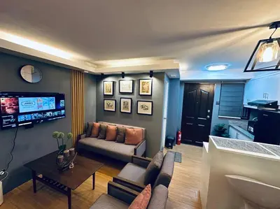 a living room with a couch and a tv at H&D Suites-Memories are personal in Imus