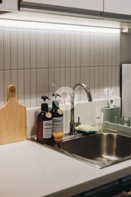 a kitchen sink with two bottles of soap on it at Somnus Suites at Air Residences in Manila