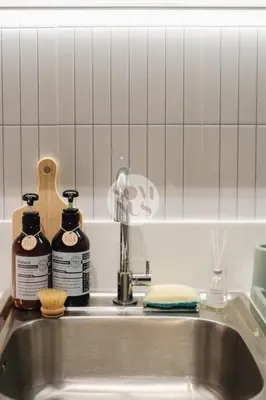 a kitchen sink with two bottles of cleaning products on it at Somnus Suites at Air Residences in Manila