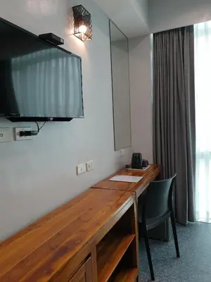 a room with a desk with a television on the wall at Leez Inn Makati in Manila