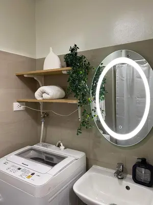 a bathroom with a washing machine and a mirror at Aesthetic walking distance to MOA,near NAIA AIRPORT with NETFLIX,MINIVIDEOKE,BOARDGAMES-DUXE2 in Manila