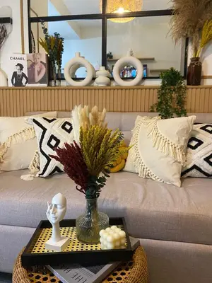 a living room with a couch with a vase on a table at Aesthetic walking distance to MOA,near NAIA AIRPORT with NETFLIX,MINIVIDEOKE,BOARDGAMES-DUXE2 in Manila