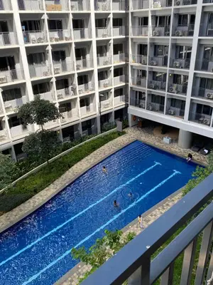an apartment building with a swimming pool in front of it at Aesthetic walking distance to MOA,near NAIA AIRPORT with NETFLIX,MINIVIDEOKE,BOARDGAMES-DUXE2 in Manila