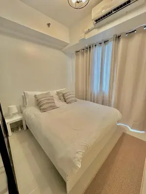 a white bed in a room with a window at Cozy Beit 1125 in Metro Manila in Manila