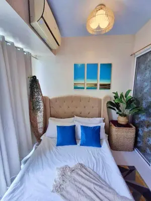 a bedroom with a large bed with blue pillows at Azure Urban Resort Parañaque Near Airport and SM Mall in Manila
