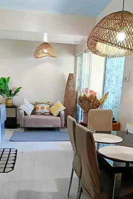 a living room with a couch and a table and chairs at Azure Urban Resort Parañaque Near Airport and SM Mall in Manila