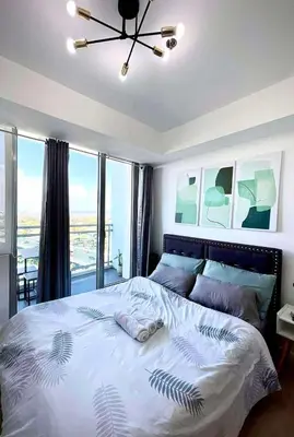 a bedroom with a large bed with a ceiling fan at Azure Urban Resort Parañaque Near Airport and SM Mall in Manila