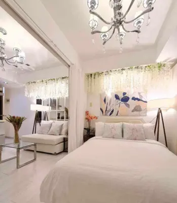 a bedroom with a large white bed and a chandelier at Azure Urban Resort Residences Paranaque Near Airport and Mall in Manila