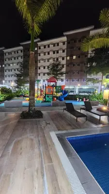 a hotel with a palm tree and a swimming pool at Empress Suite SMDC Hope Residences CONDOTEL with UNLIWIFI in Trece Martires