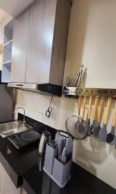 a kitchen with a stove and a counter with utensils at Empress Suite SMDC Hope Residences CONDOTEL with UNLIWIFI in Trece Martires