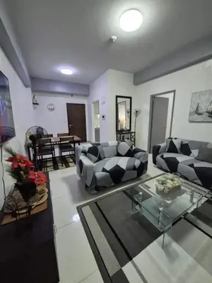 a living room with two couches and a glass table at SMT Condo Hotel in Manila