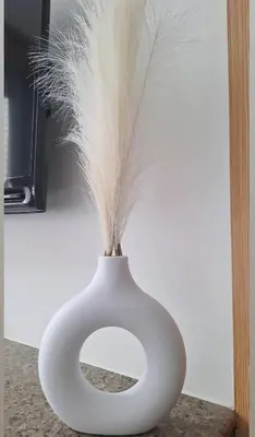 a white vase with feathers sticking out of it at Cozy Staycation in Manila