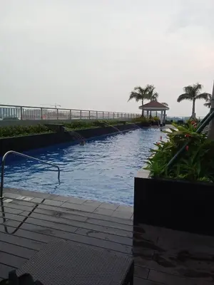 a swimming pool next to the beach with a pier at Condo With Water Views in Manila