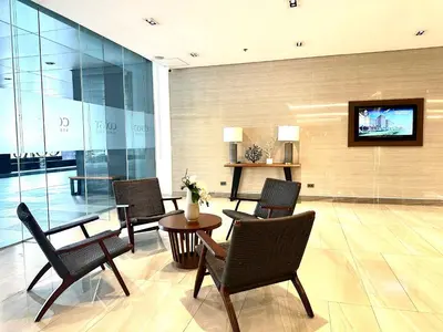 a lobby with chairs and a table and a tv at Cozy Nook at Coast Residences in Manila