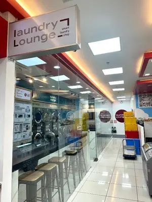 a store with a laundry lounge with stools at Cozy Nook at Coast Residences in Manila