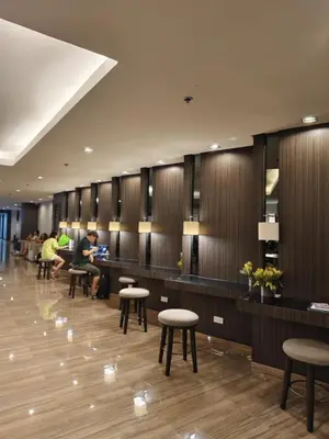 a waiting room with tables and stools in a building at Air Residences Suite by Christine Suites PH in Manila
