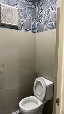 a bathroom with a white toilet in a room at FACE Transient Rooms in Kawit