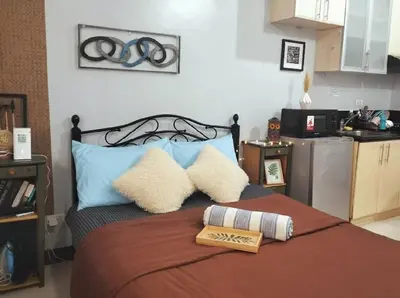 a bedroom with a bed with two pillows on it at Cozy Home in BGC McKinley B2 in Manila