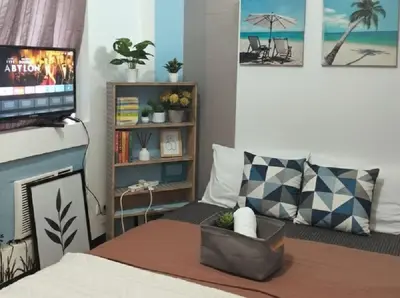 a living room with a bed with a tv and a couch at Heart of BGC McKinley B3 in Manila