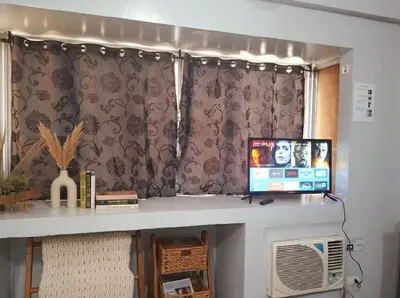 a room with a desk with a computer and a window at Heart of BGC McKinley B3 in Manila