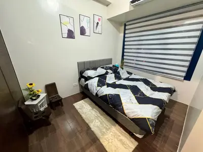 a bedroom with a bed and a window in it at Air Residences 43rdF -By Soliel in Manila