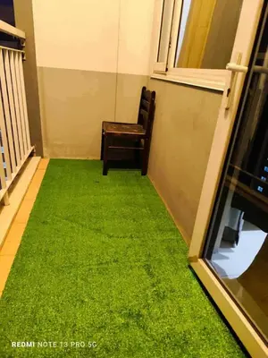 a chair sitting on a balcony with green grass at SD2 tandem staycation in Manila