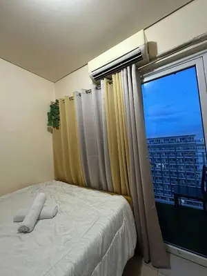 a bedroom with a bed and a window with a view at SD2 tandem staycation in Manila