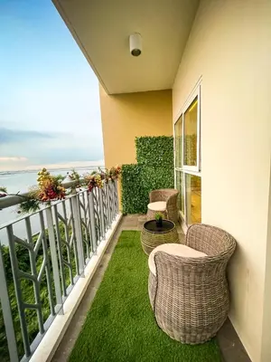 a balcony with two wicker chairs and a table at Modern Luxury 4BR Manila Bay beside Okada Manila in Manila
