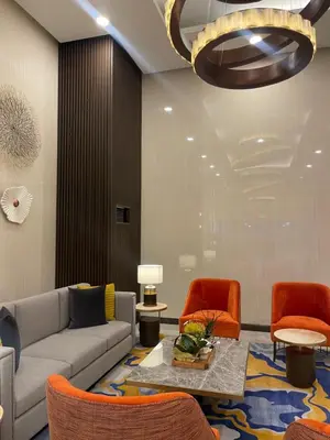 a living room with a couch and orange chairs at Luxurious 3BR in Manila Bay beside Okada in Manila