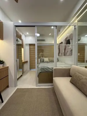 a living room with a bed and a couch at Antoneitte Staycation in Manila