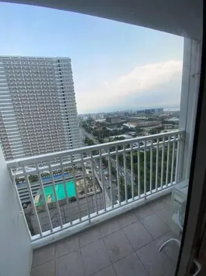 a balcony with a view of a building at Breeze Residences 26th floor in Manila