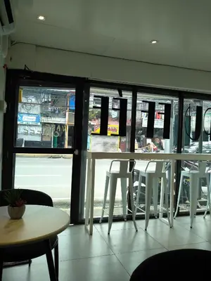 a restaurant with a table and chairs in front of a window at Brokeside in Cainta