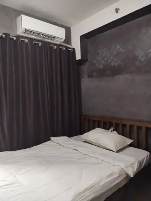 a bedroom with a bed with a curtain and a air conditioner at Casa Reyes in Manila
