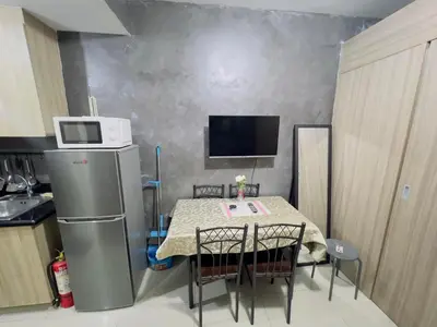 a small kitchen with a table and a refrigerator at Casa Reyes in Manila