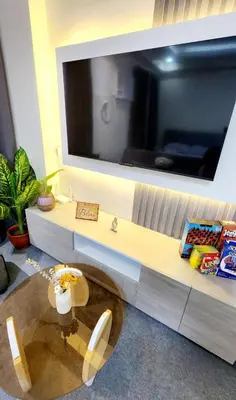 a living room with a table and a tv on a wall at Primo Stay in Trece Martires