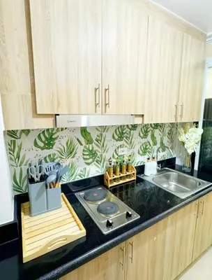 a kitchen with wooden cabinets and a counter top at Plete's Suite in Manila