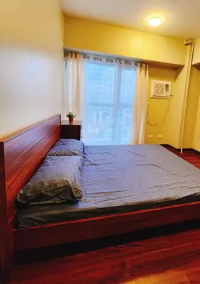 a large bed in a room with a large window at Furnished 2Bedroom 2Bathroom plus Utility Room with 2 Beds in Manila