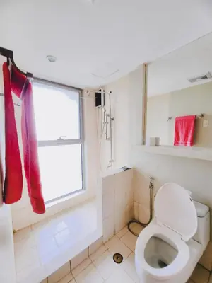 a white bathroom with a toilet and a window at Furnished 2Bedroom 2Bathroom plus Utility Room with 2 Beds in Manila