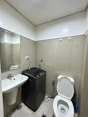 a bathroom with a sink and a toilet and a mirror at shore 880 staycation in Manila