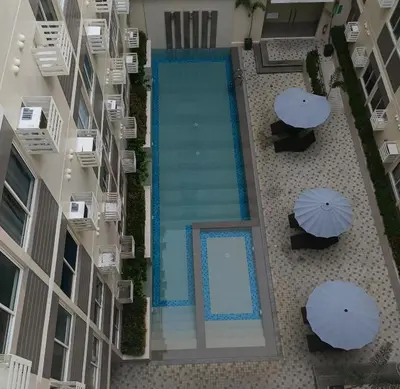 an overhead view of a swimming pool in a building with umbrellas at Miranda's Suite by Fullerton in Silang